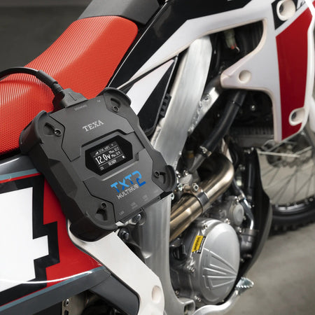 Close-up of a red and black dirt bike with a TEXA TXT MULTIHUB 2 attached.